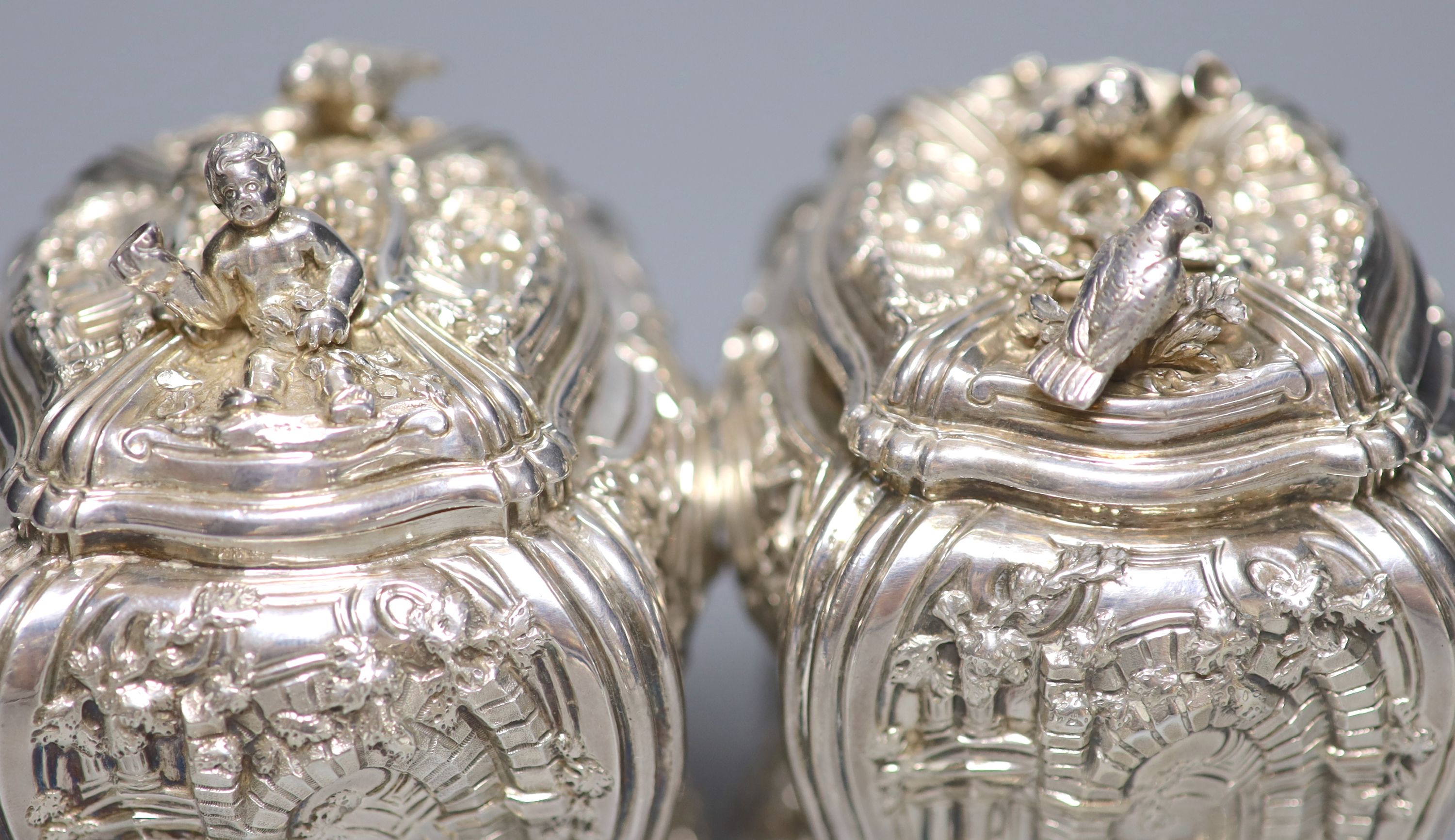 A good pair of George II embossed silver tea caddies and covers, by Elizabeth Godfrey, London, 1749/50, housed in a later 19th century pierced Canton ivory mounted caddy, with velvet interior